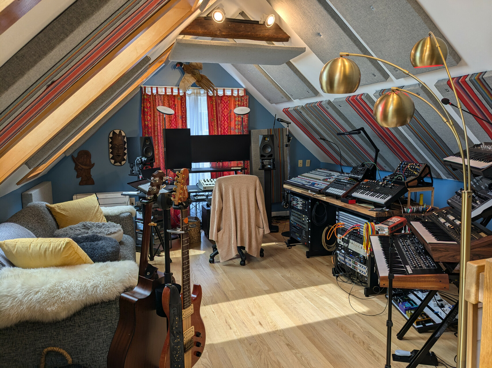 Alison's beautiful studio with a dual monitor setup, guitars, a couch, a mixing console, patch bays, outboard equipment and synthesizers